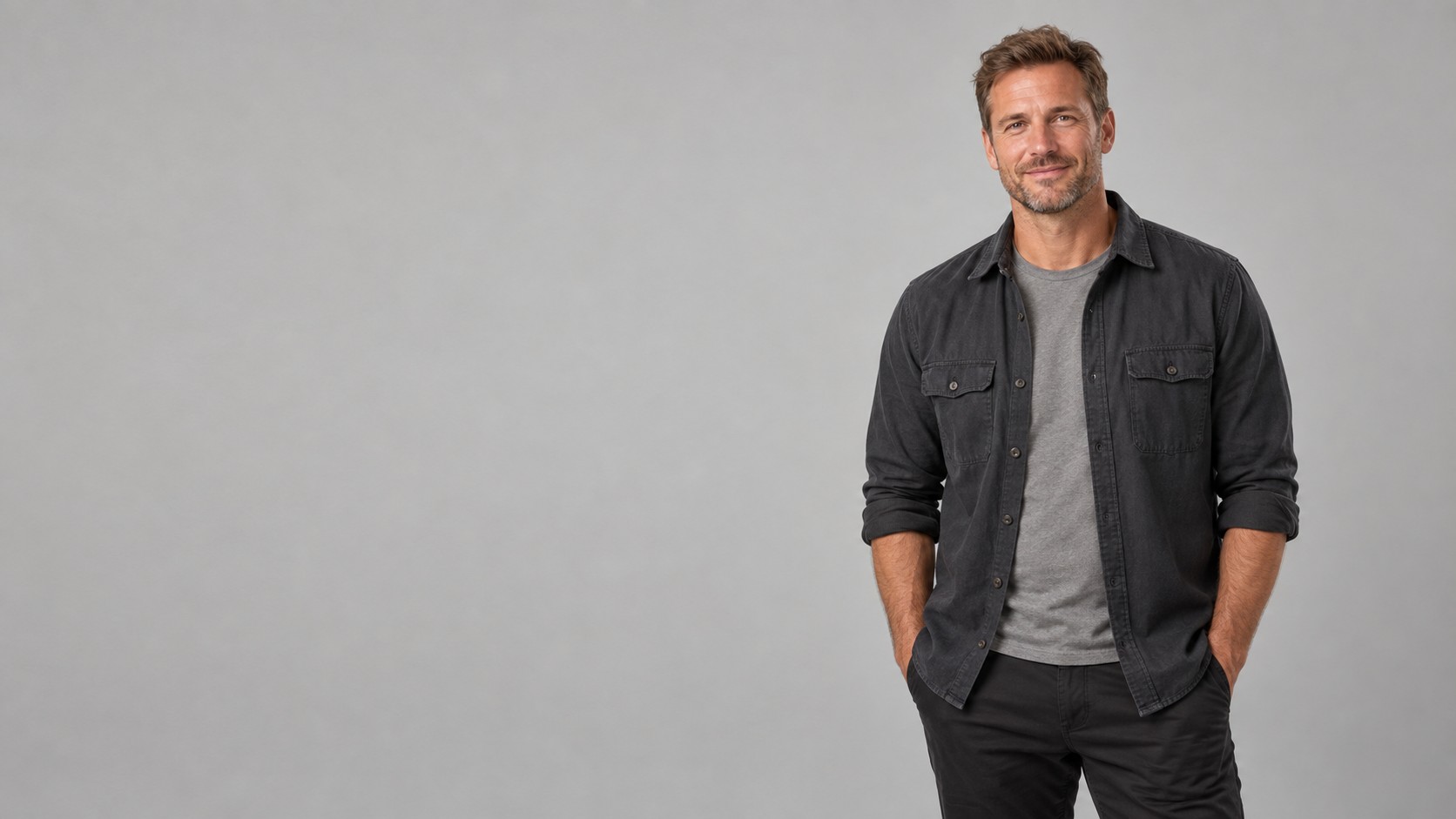 Entrepreneur in a charcoal overshirt against a soft stone-grey studio backdrop